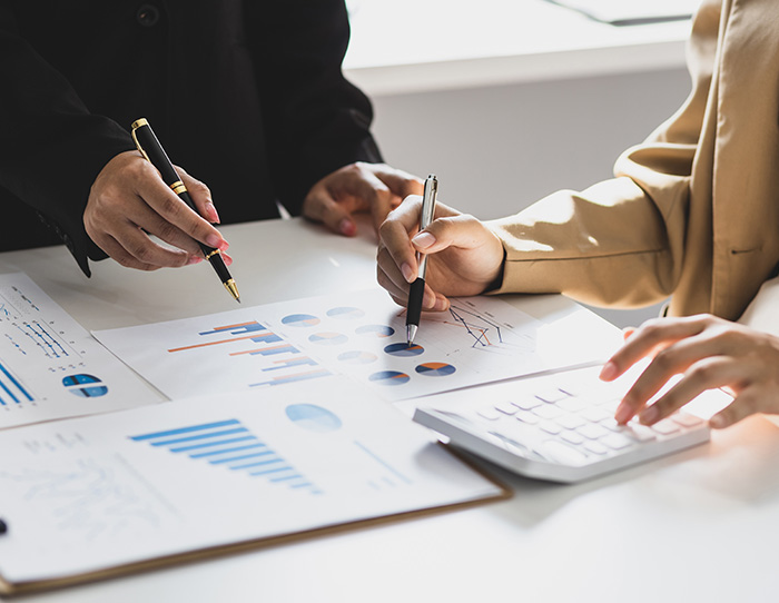 Two people looking over statistic documents - Premium Funding